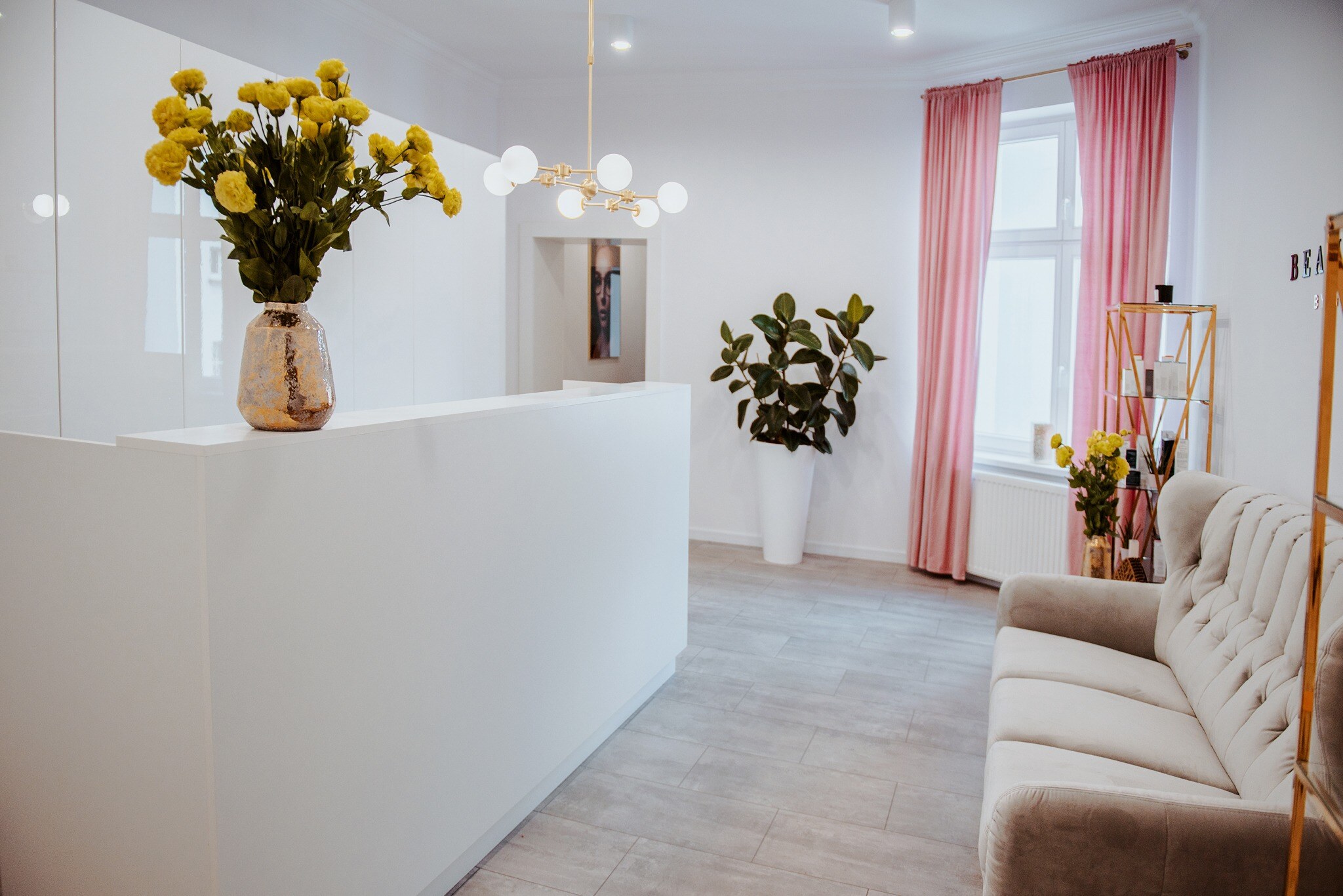 Biała lada recepcyjna i zabudowa w salonie beauty